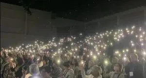ICN Congress attendees shining mobile phone torches in commemoration of colleagues working on the front lines of conflict zones